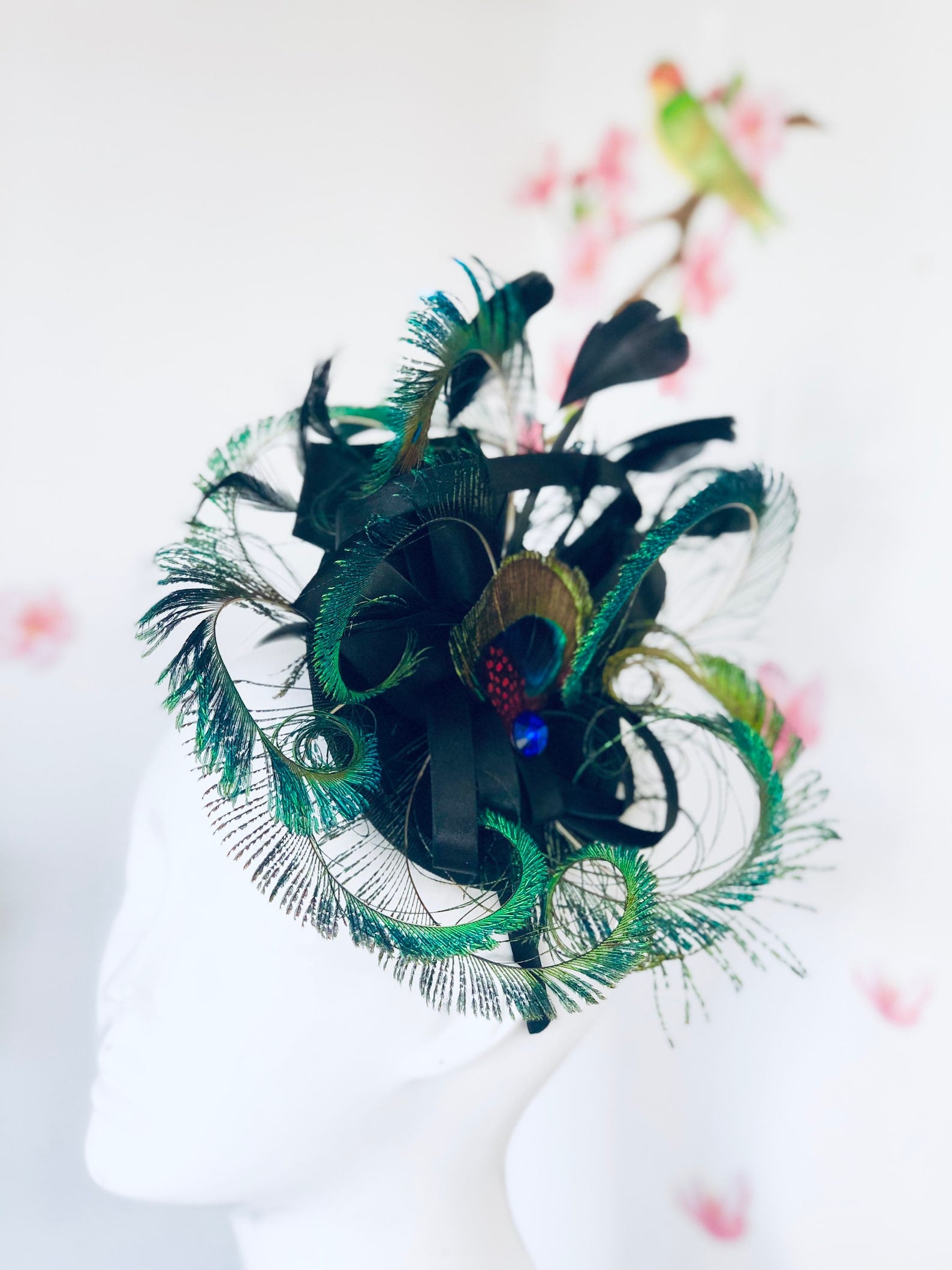 Black fascinator hat with peacock feathers.