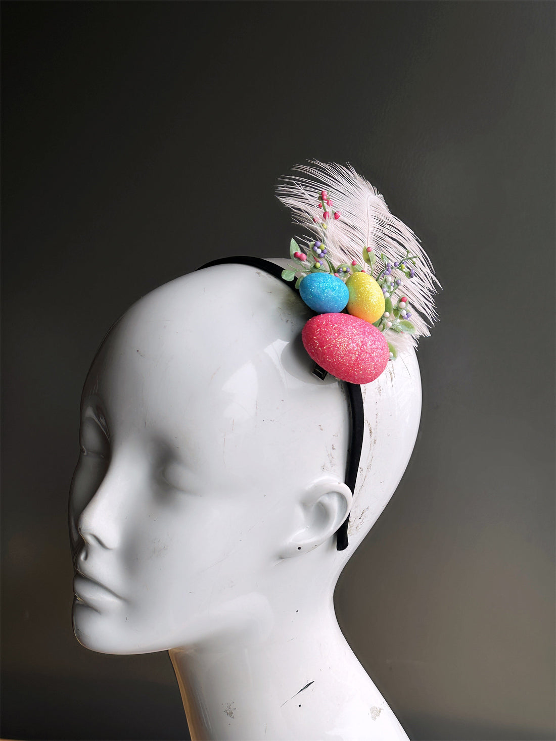 Headband with feathers, floral accents, and pink/blue/yellow easter eggs.