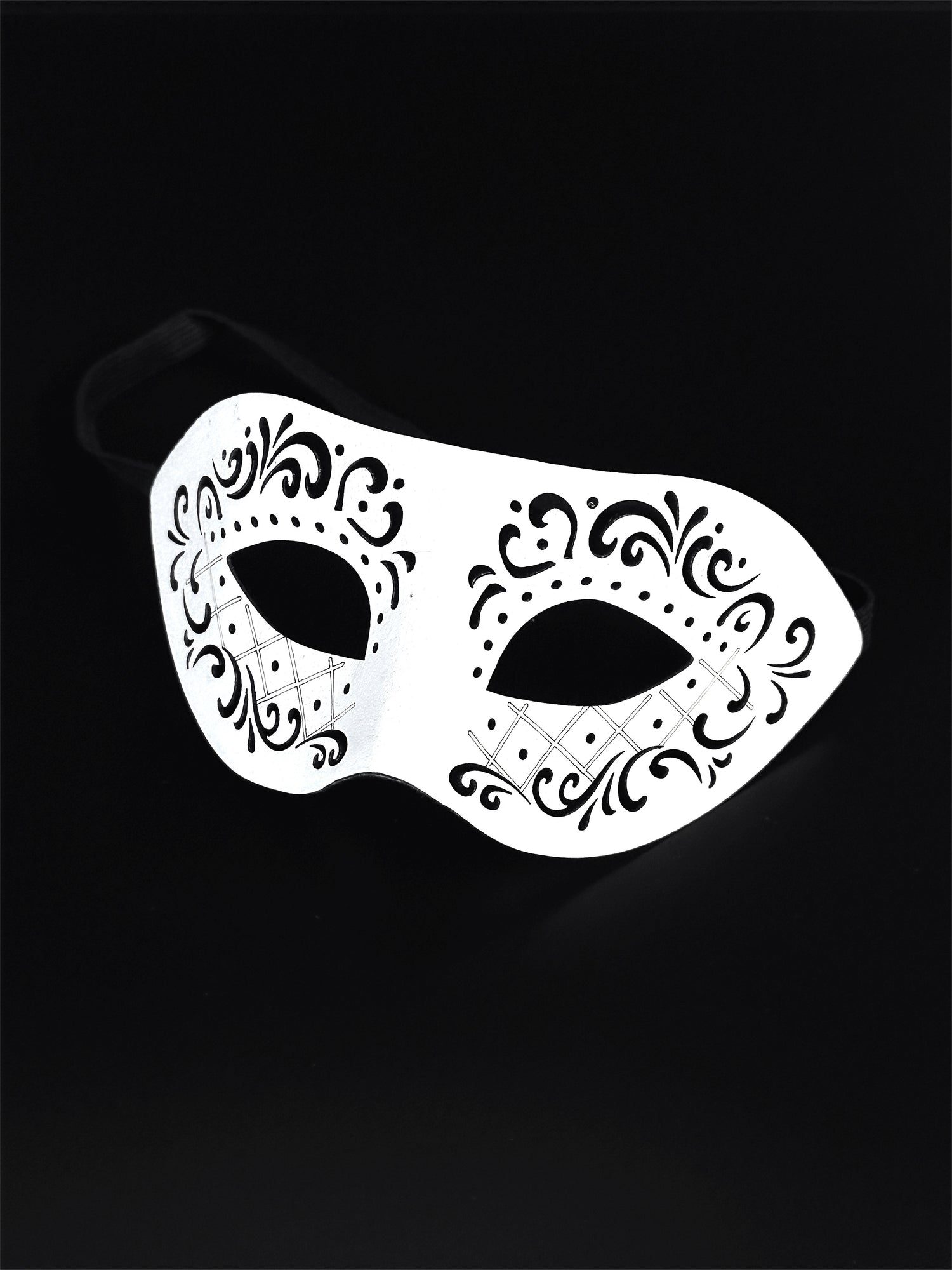 White vegan leather masquerade mask with an engraved design.