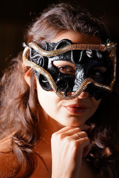 Women's medusa snake masquerade mask in black with a gold snake.