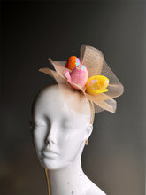 Easter fascinator hat with gold tulle and sequin easter eggs in orange, pink, and yellow.