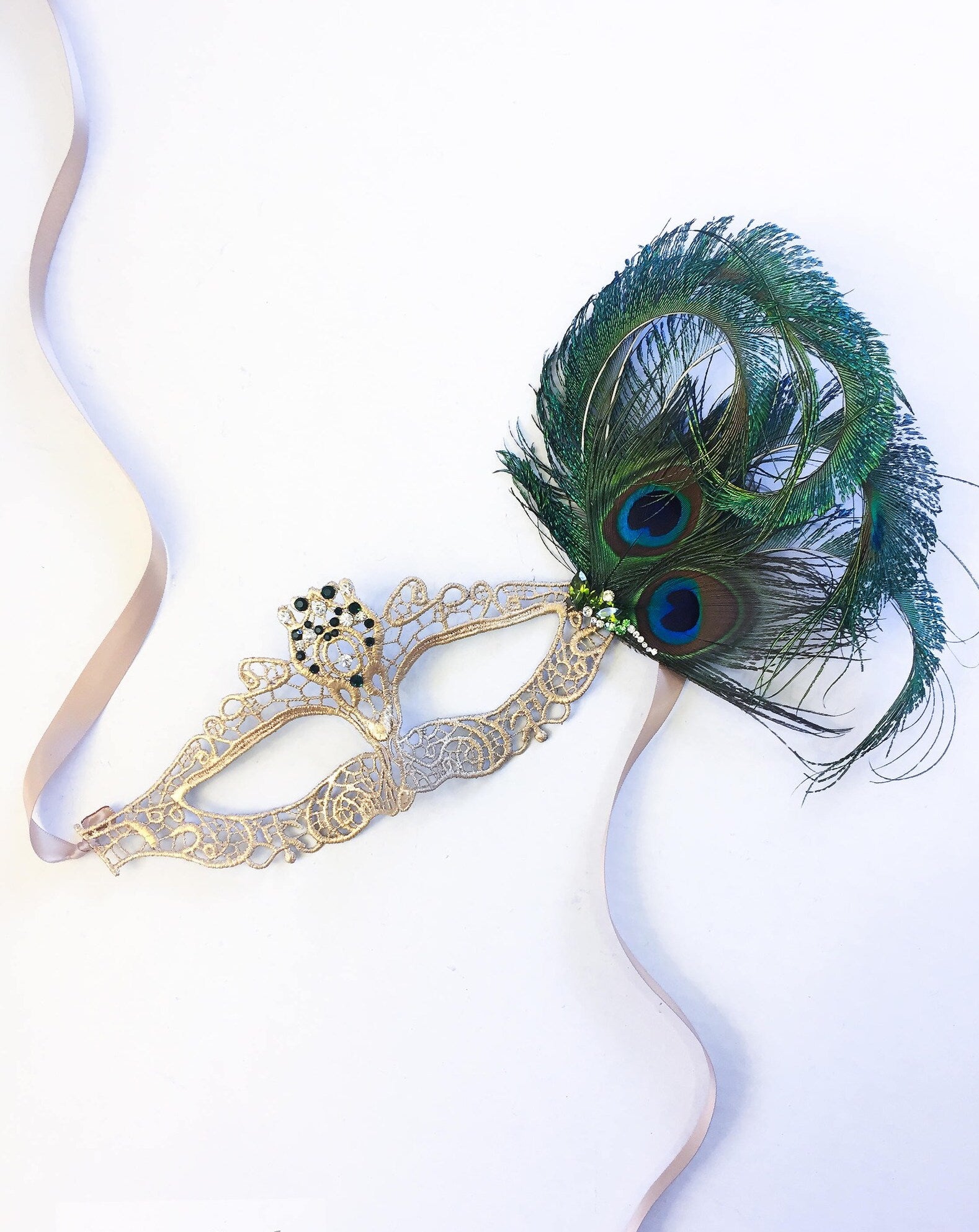 Gold lace mask with peacock feathers and green and clear rhinestones.