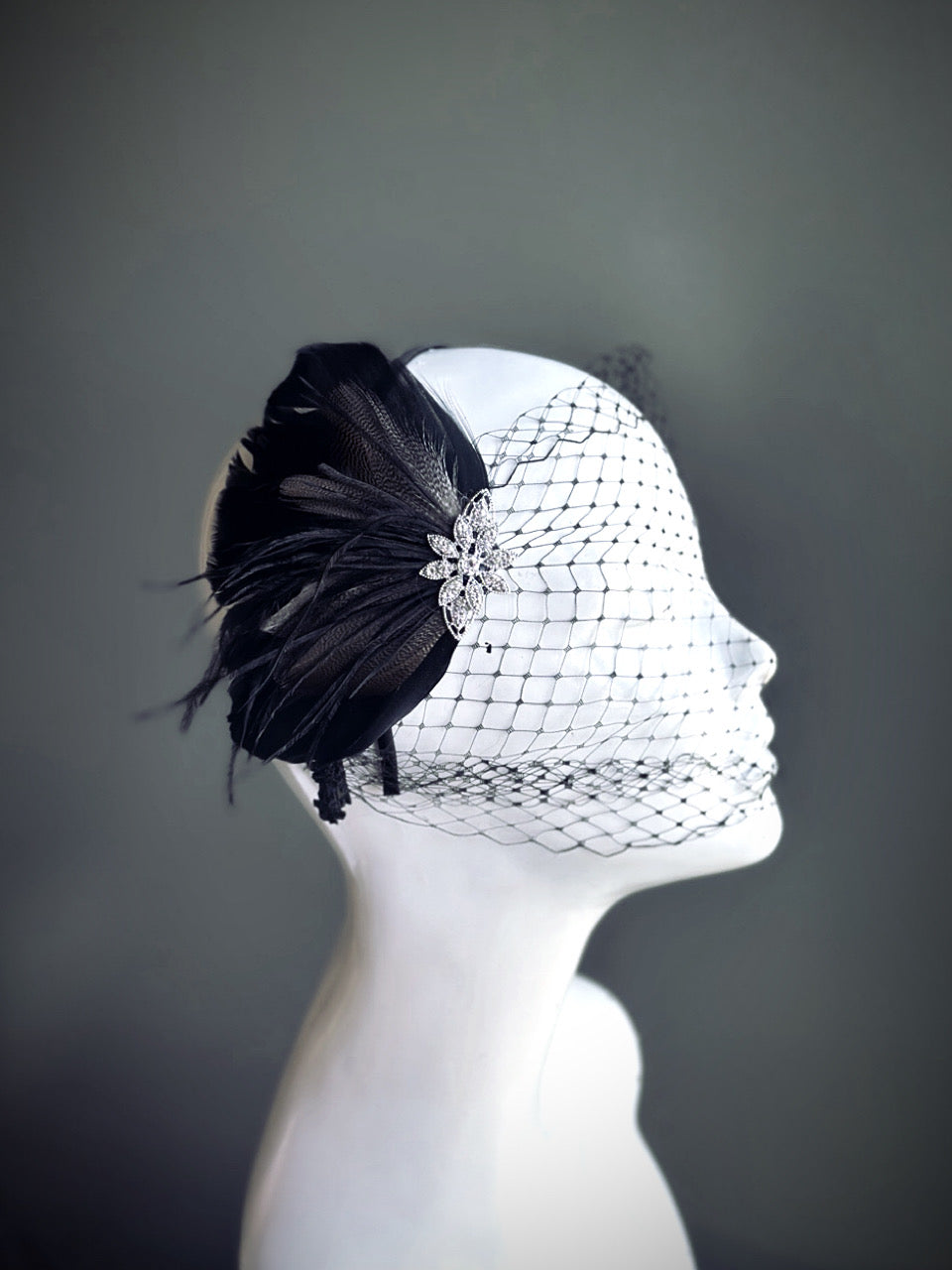 &quot;Black feather fascinator with a rhinestone accent and dotted mesh veil, perfect for weddings and formal occasions.&quot;

