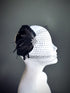 "Black feather fascinator with a rhinestone accent and dotted mesh veil, perfect for weddings and formal occasions."

