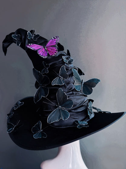 Black witch hat adorned with black butterflies and a standout purple butterfly, ideal for Halloween and gothic events.