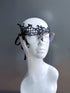 Black lace masquerade mask designed for eyeglass wearers displayed on a white mannequin head.