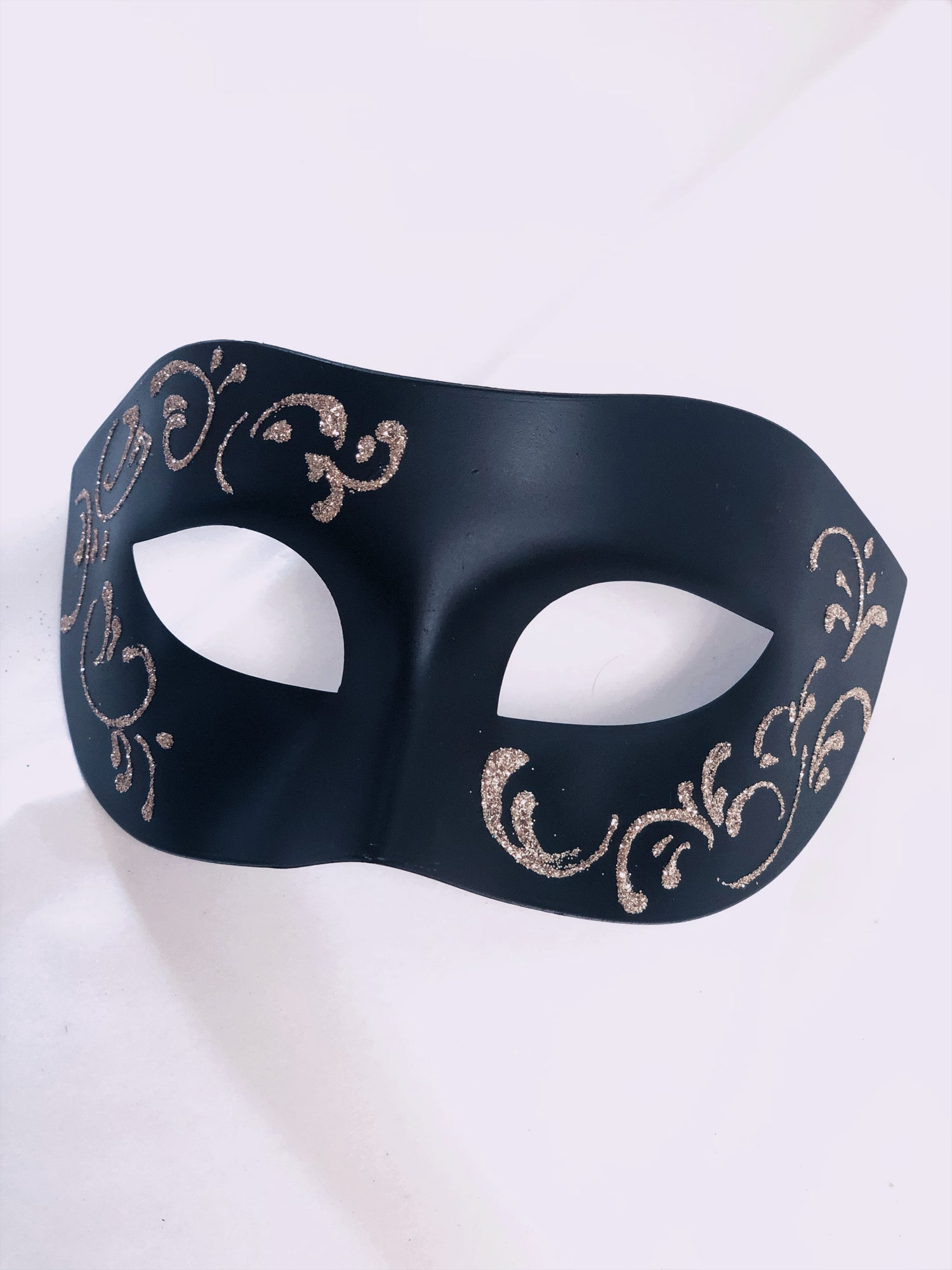 Black masquerade mask with intricate gold filigree design for men’s formal events.