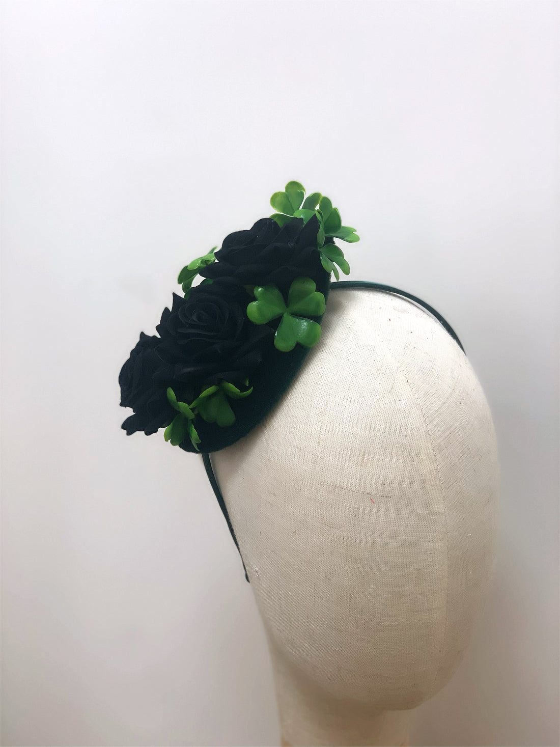 Black rose fascinator with four-leaf clovers on a headband, perfect for adding a unique touch to any outfit.