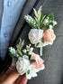 A stunning artificial floral boutonniere and corsage set in shades of pink, green, and white.