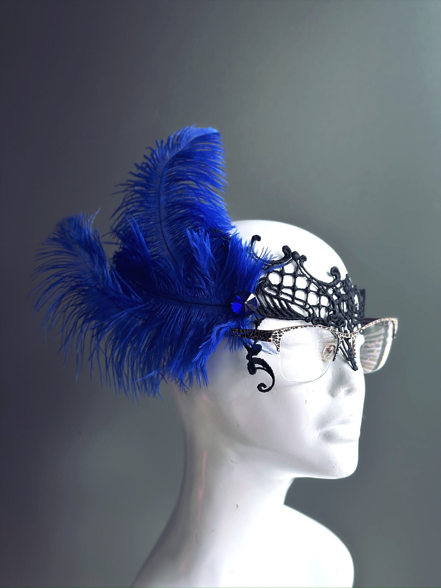 Blue Feather Masquerade Mask with black lace, designed to fit over glasses, adorned with vibrant blue feathers.