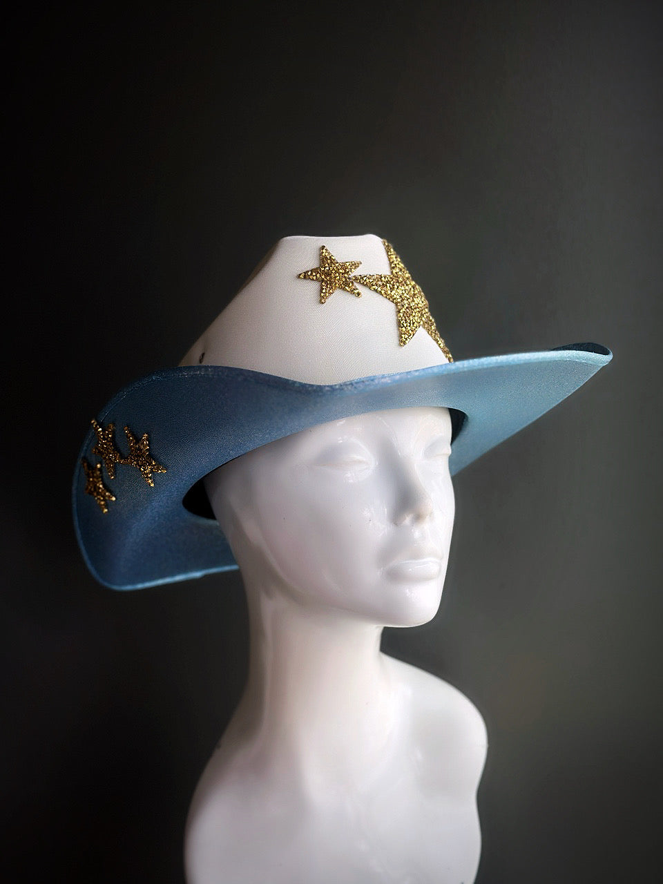 Blue and white cowboy hat with gold glitter stars, featuring a shimmering design perfect for festivals, rodeos, and themed parties.