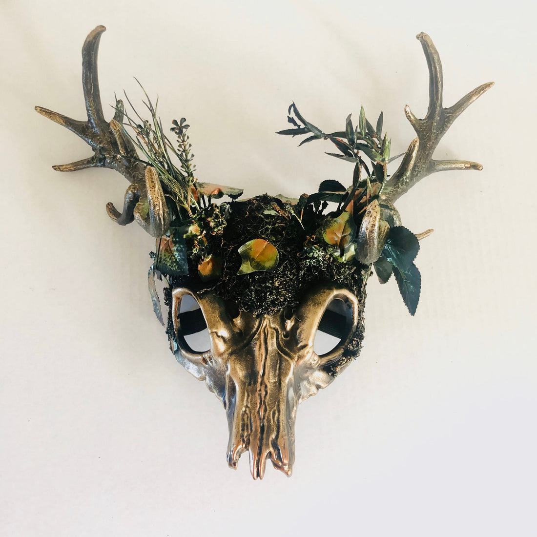 Cernunnos-inspired antler skull headdress with moss, gold-tone antlers, and woodland foliage. Ideal for pagan rituals and Celtic celebrations.