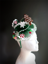 Green Christmas fascinator decorated with gingerbread, candy accents, and a snowflake design, ideal for holiday events and celebrations.