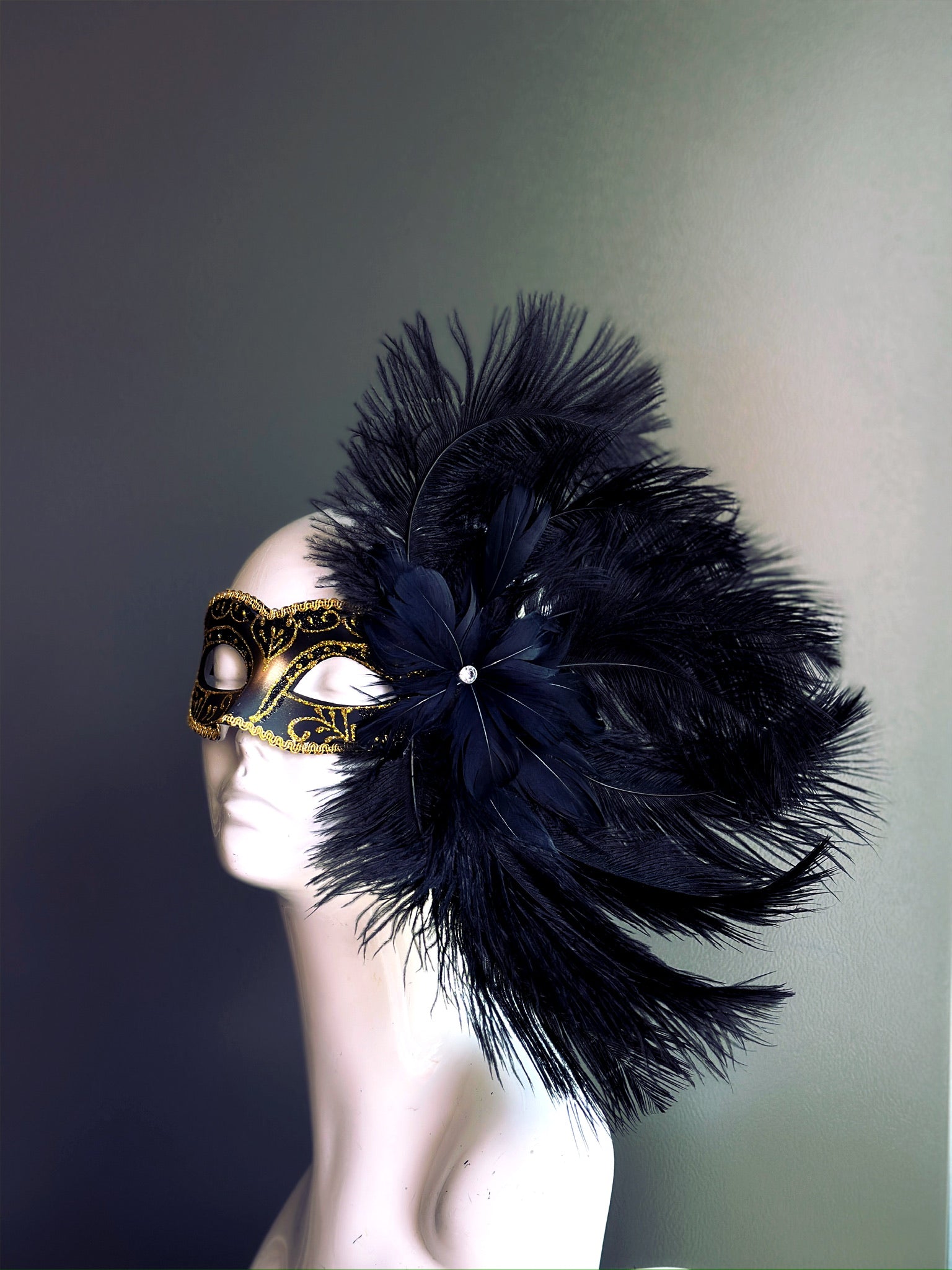 Elegant Black Feather Mask with luxurious black feathers and ornate gold accents for a refined masquerade look.