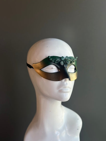 Green and gold masquerade mask with a filigree accent, offering a sophisticated and mysterious design.