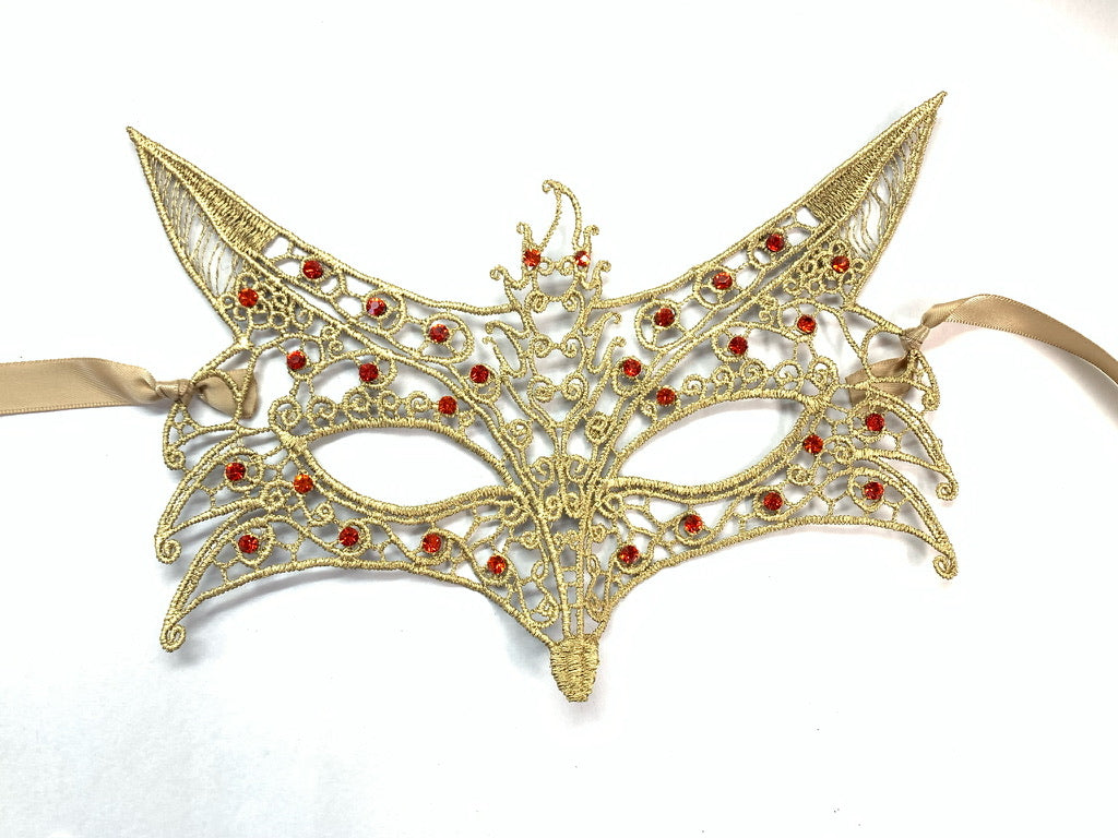 Fox-inspired lace mask in gold with detailed design and red stones, tied with satin ribbons for a luxurious finish.