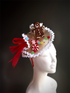  A delightful fascinator featuring a smiling gingerbread man, colorful candy accents, and festive red ribbon. Perfect for holiday parties and celebrations.