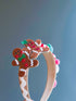 Holiday-themed headband with gingerbread characters and colorful candy accents, perfect for festive celebrations.