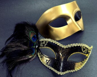 Gold Venetian mask paired with an ornate black mask featuring intricate details and a vibrant peacock feather, ideal for elegant occasions.