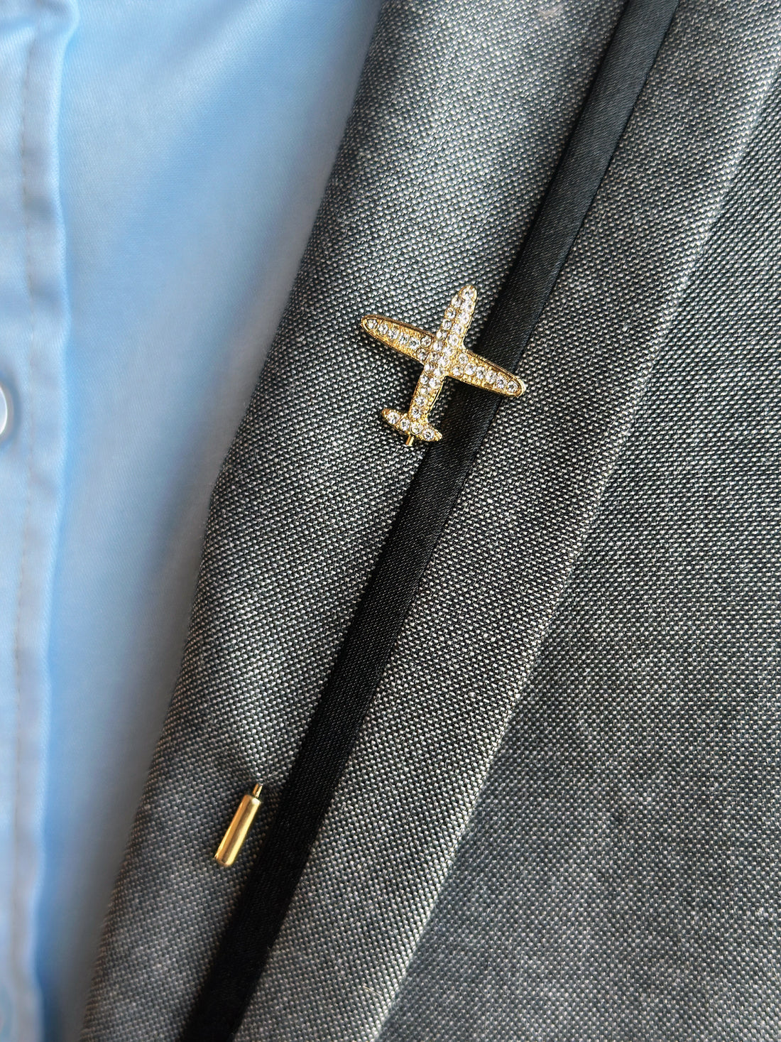 Gold crystal airplane lapel pin, a stylish and elegant accessory for aviation enthusiasts or formal occasions.