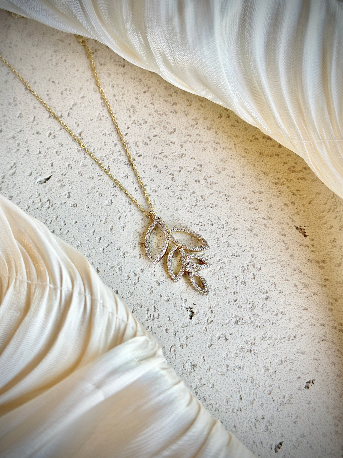 Gold necklace with a leaf-shaped crystal pendant, hypoallergenic, non-tarnish, and waterproof—ideal for effortless elegance and everyday wear.