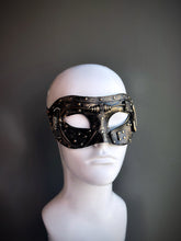 Gold steampunk masquerade mask with industrial details and riveted accents displayed on a mannequin head.

