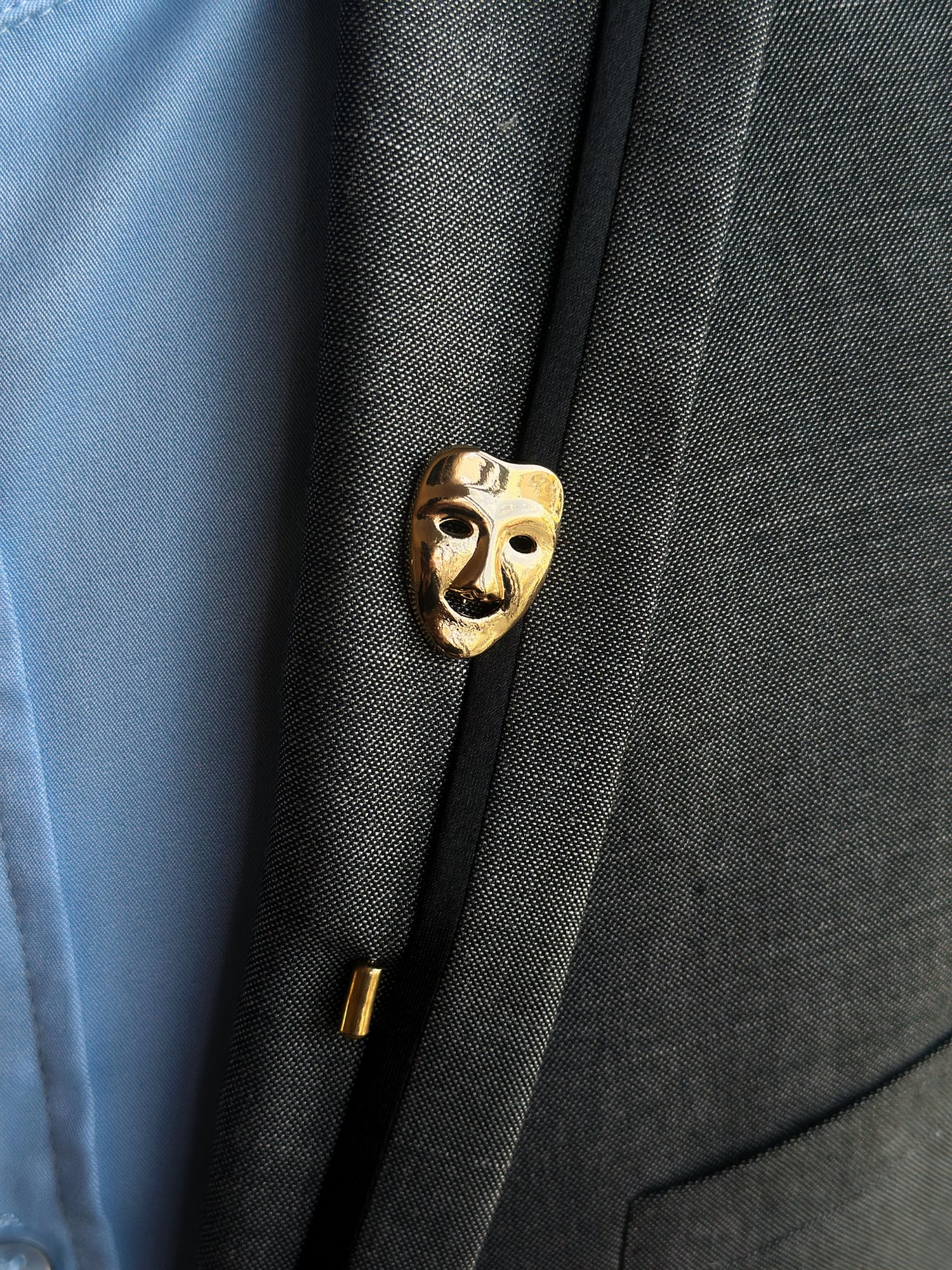 Gold theater mask lapel pin, an elegant and artistic accessory for drama enthusiasts and formal attire.