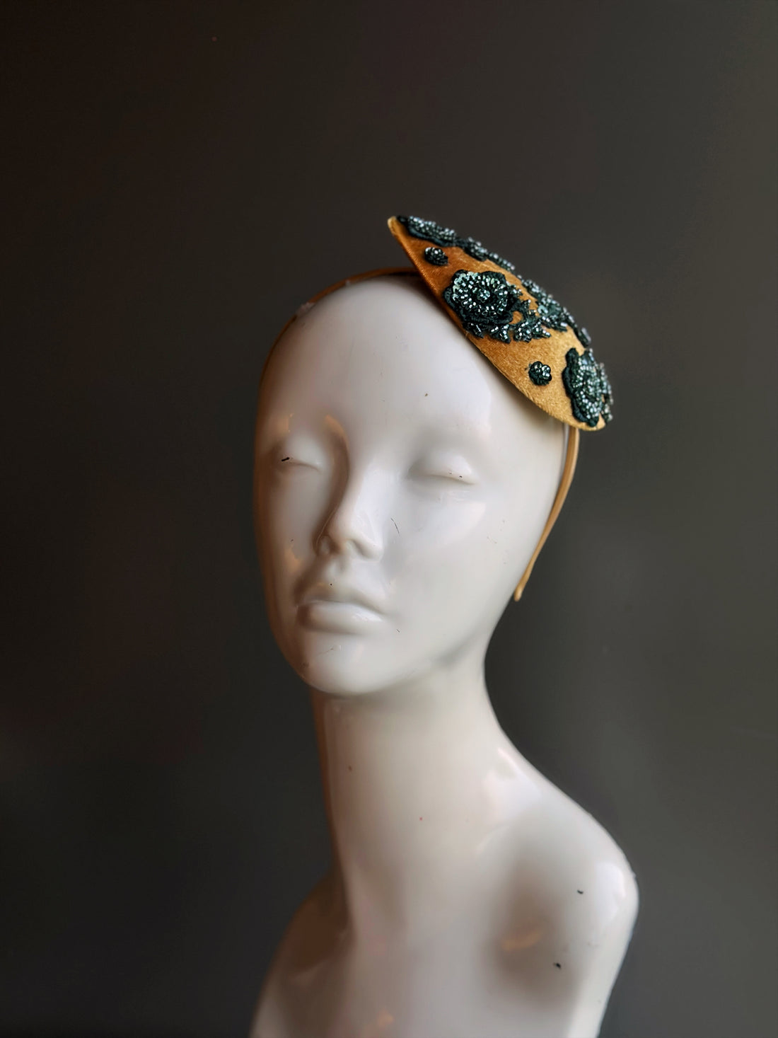 Golden velvet fascinator featuring intricate green beadwork, perfect for Christmas parties and festive occasions.