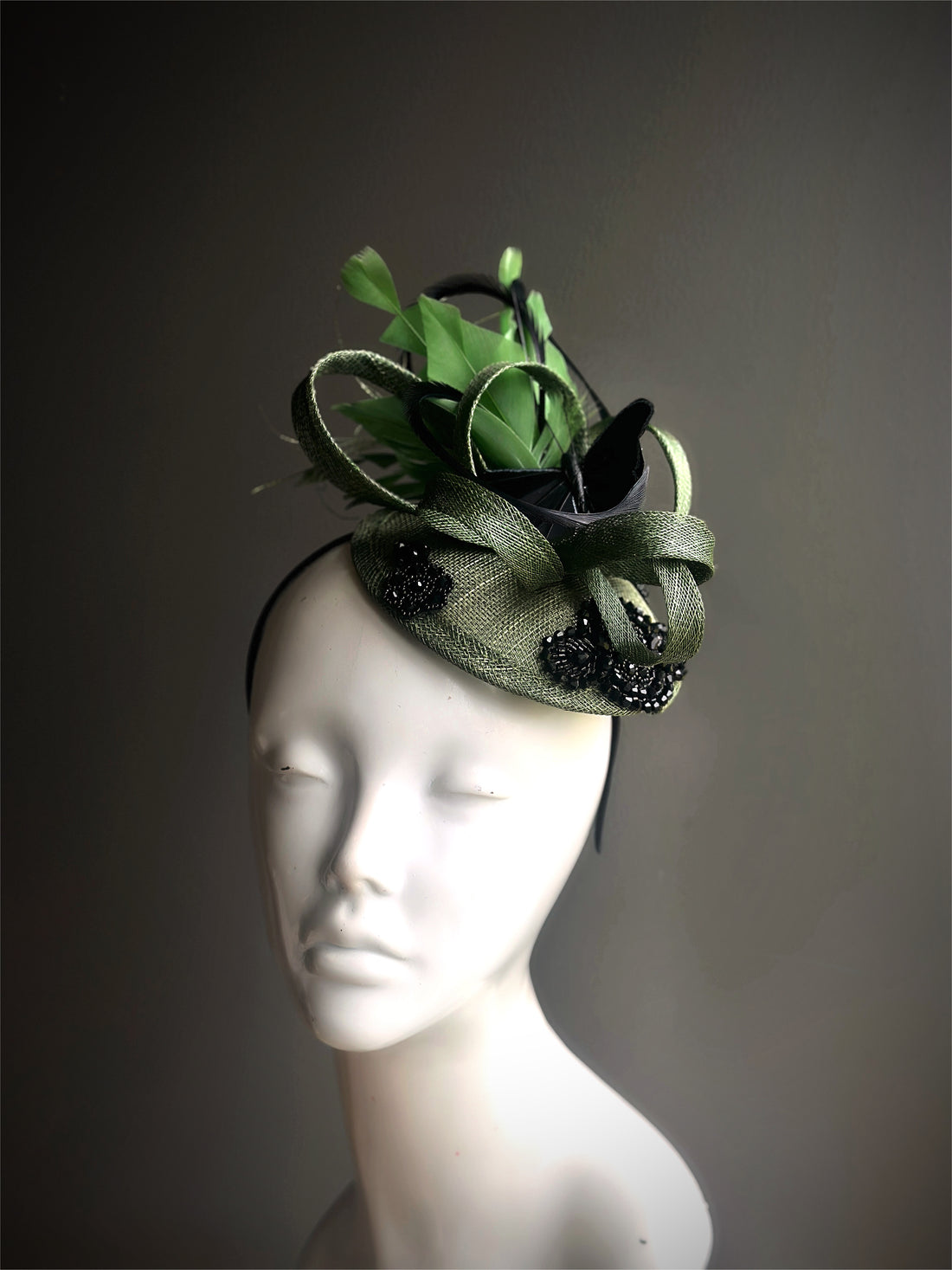 Green and black fascinator with black butterflies, beaded accents, loops, and feathers, ideal for weddings, formal events, or race day outfits.