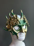 Green and gold mask with woodland-inspired accents and floral detailing, ideal for fantasy-themed events or elegant costume parties.