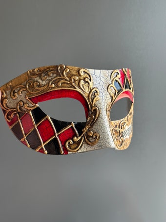 Venetian-style mask with a red, black, and gold harlequin pattern and ornate gold detailing, ideal for formal occasions.