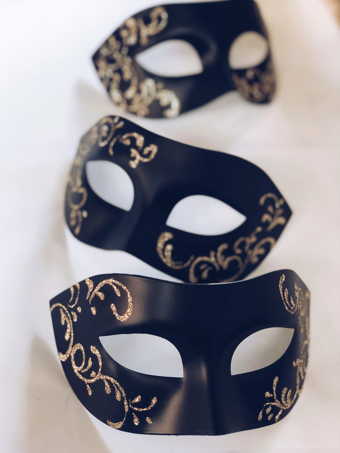 Luxury black masquerade masks with gold detailing, available in bulk for weddings, parties, or events.