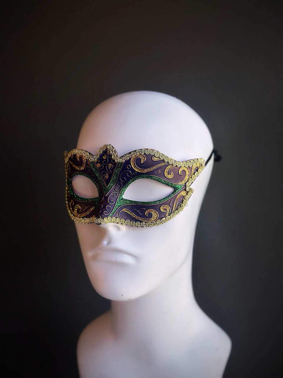 Classic Mardi Gras mask featuring rich purple, green, and gold tones with elegant swirling details for a traditional Venetian style.