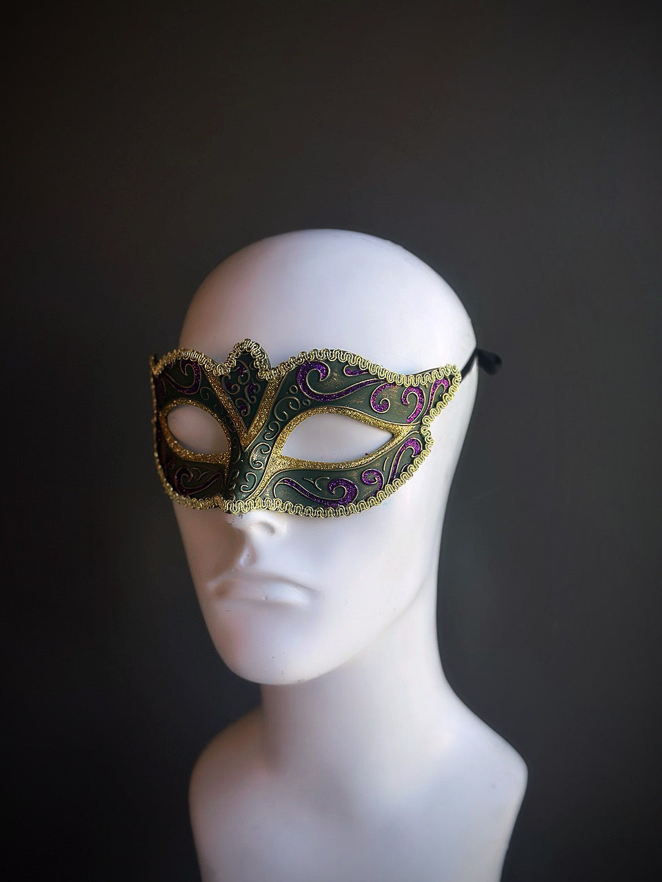 Venetian-inspired Mardi Gras mask in green, purple, and gold with intricate detailing and elegant design for a sophisticated look.