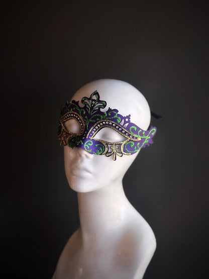 Purple and green Mardi Gras mask with gold filigree details and rhinestones, designed for a sophisticated and festive look.