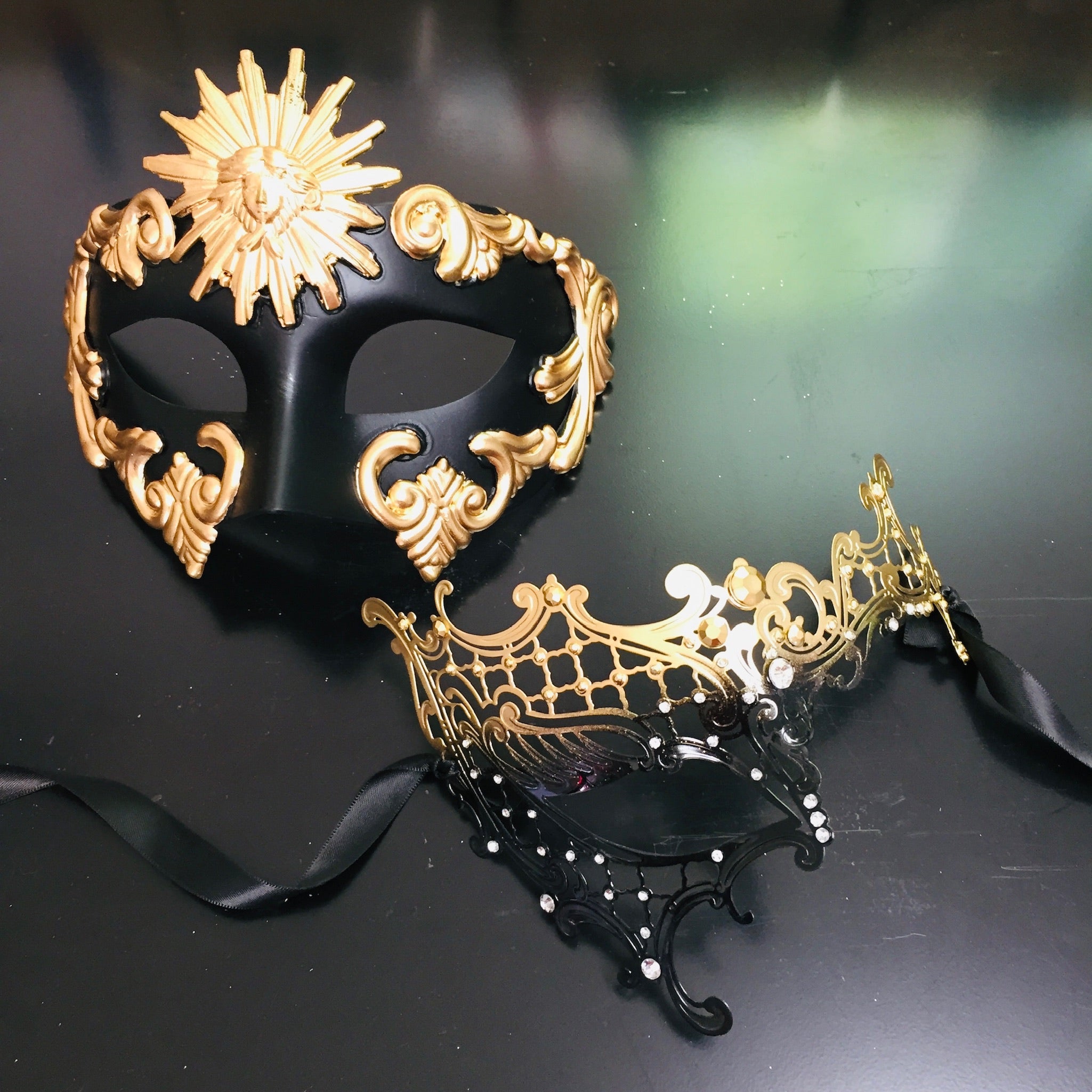 Sun God and Phantom masquerade masks in gold and black for couples with intricate metal filigree and resin accents