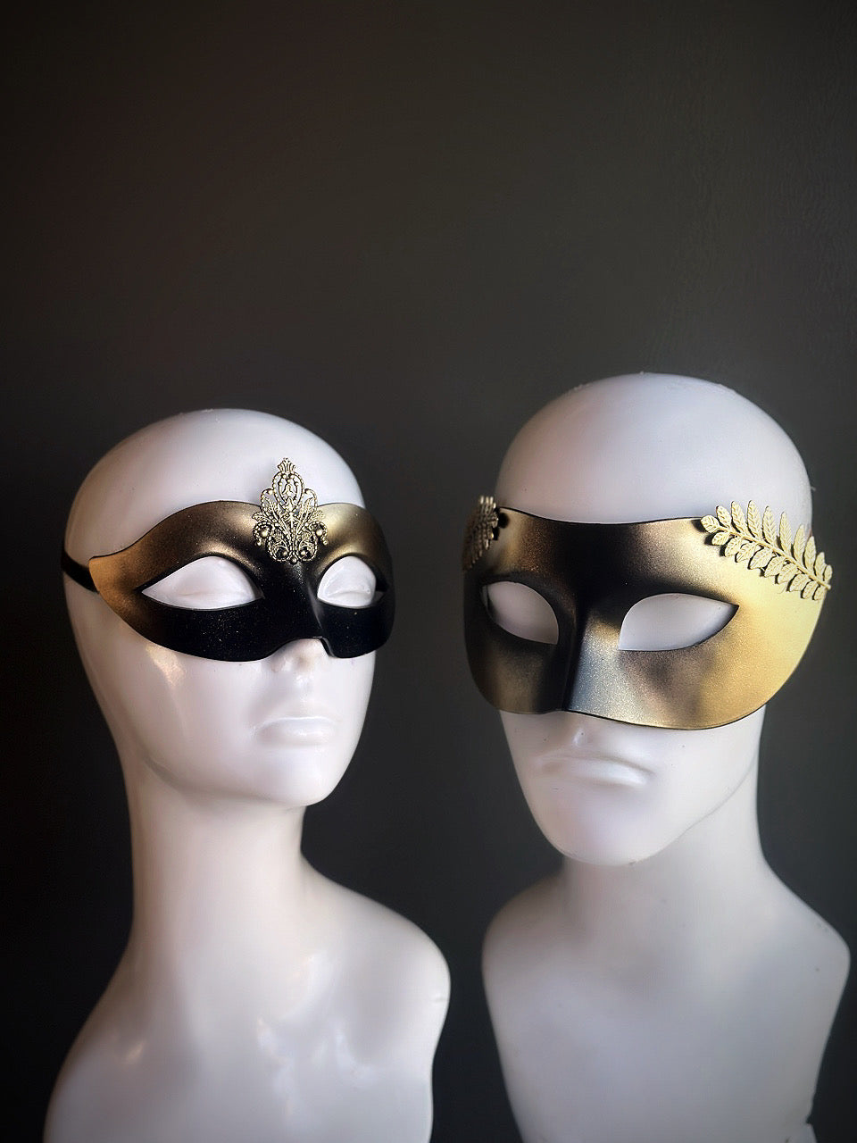 Elegant black and gold masquerade mask set with regal filigree and laurel accents, designed for couples seeking a sophisticated look.