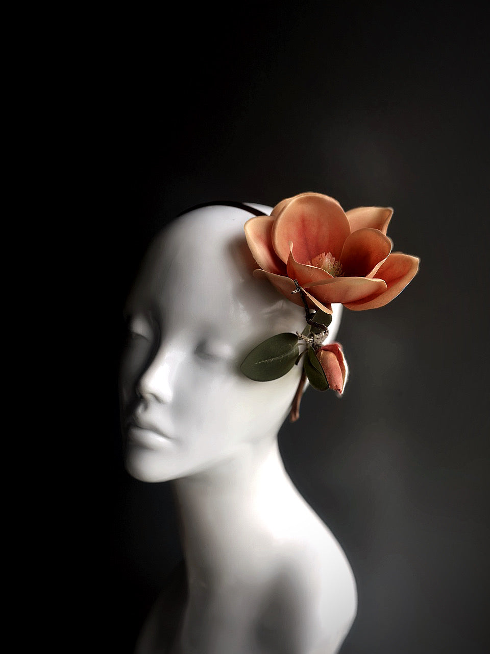 Orange magnolia fascinator with realistic leaves, ideal for autumn weddings, garden parties, or elegant occasions.