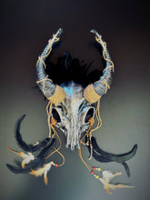 ram horn skull headdress featuring intricate hand-finished details, twine-wrapped horns, and ritualistic feather adornment