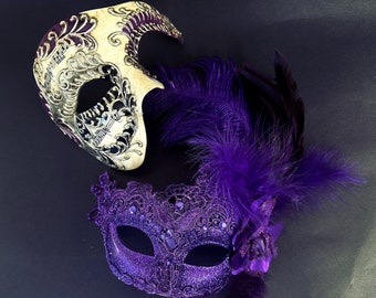 Ivory Venetian-style mask with purple accents paired with a lace-detailed purple mask featuring feathers and a floral accent, ideal for elegant occasions.