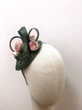 Fascinator hat with delicate roses and sculpted loops, designed for elegant occasions and year-round wear.