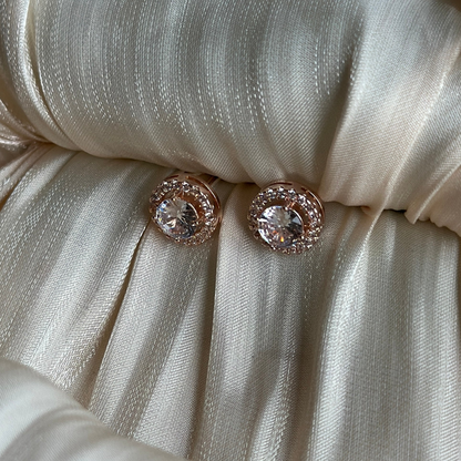 Rose gold earrings with round-cut crystals encased in a double halo of shimmering stones.