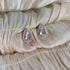 Rose gold pear-shaped cubic zirconia stud earrings with a halo setting, designed for a sophisticated and radiant look.

