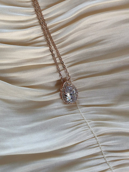  Rose gold teardrop pendant necklace with shimmering cubic zirconia on a delicate chain.