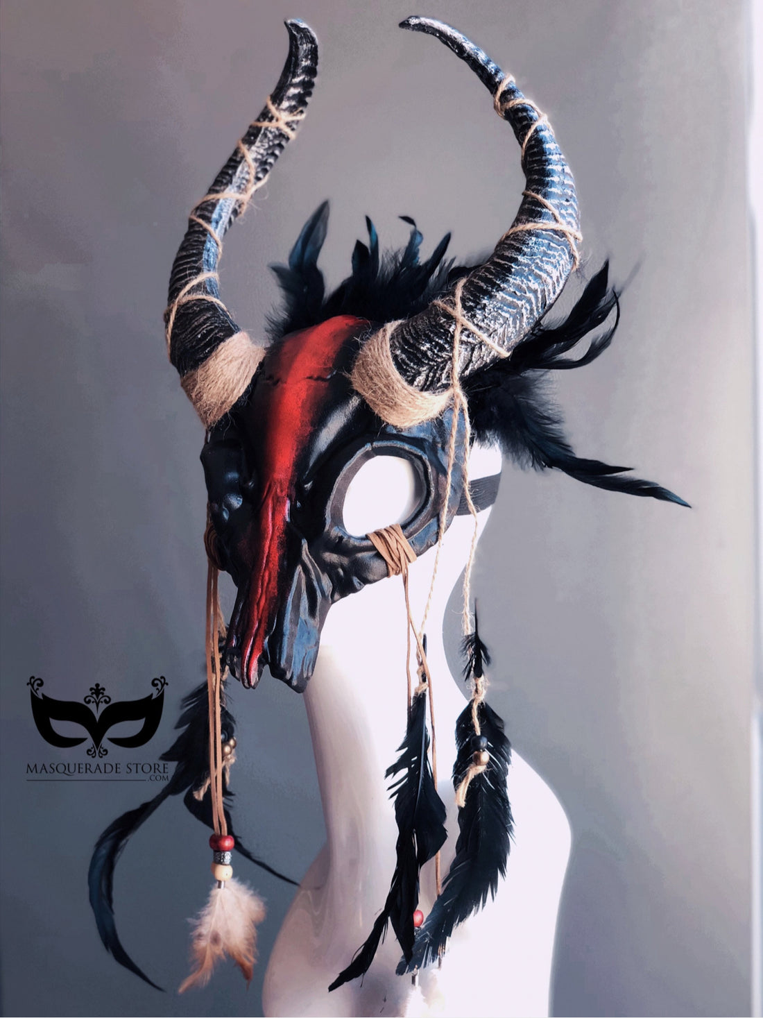 Salem Witch ram horn headdress with red and black design, twine bindings, and black feathers.