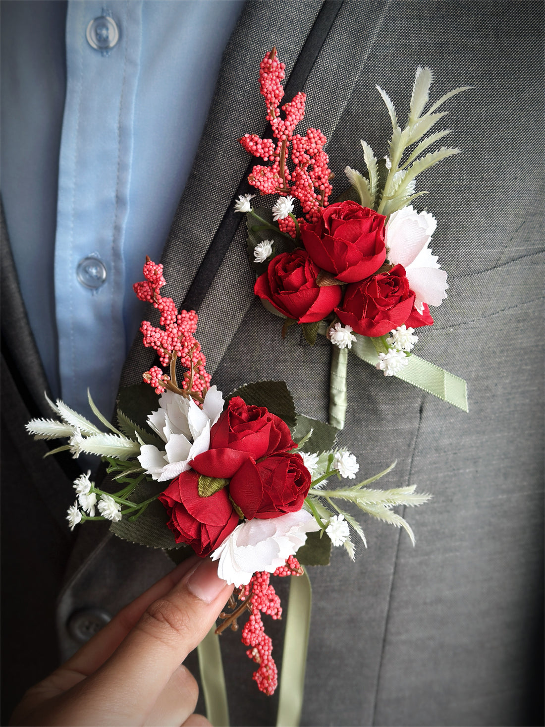 A stunning artificial floral boutonniere and corsage set in shades of red, green, and white.