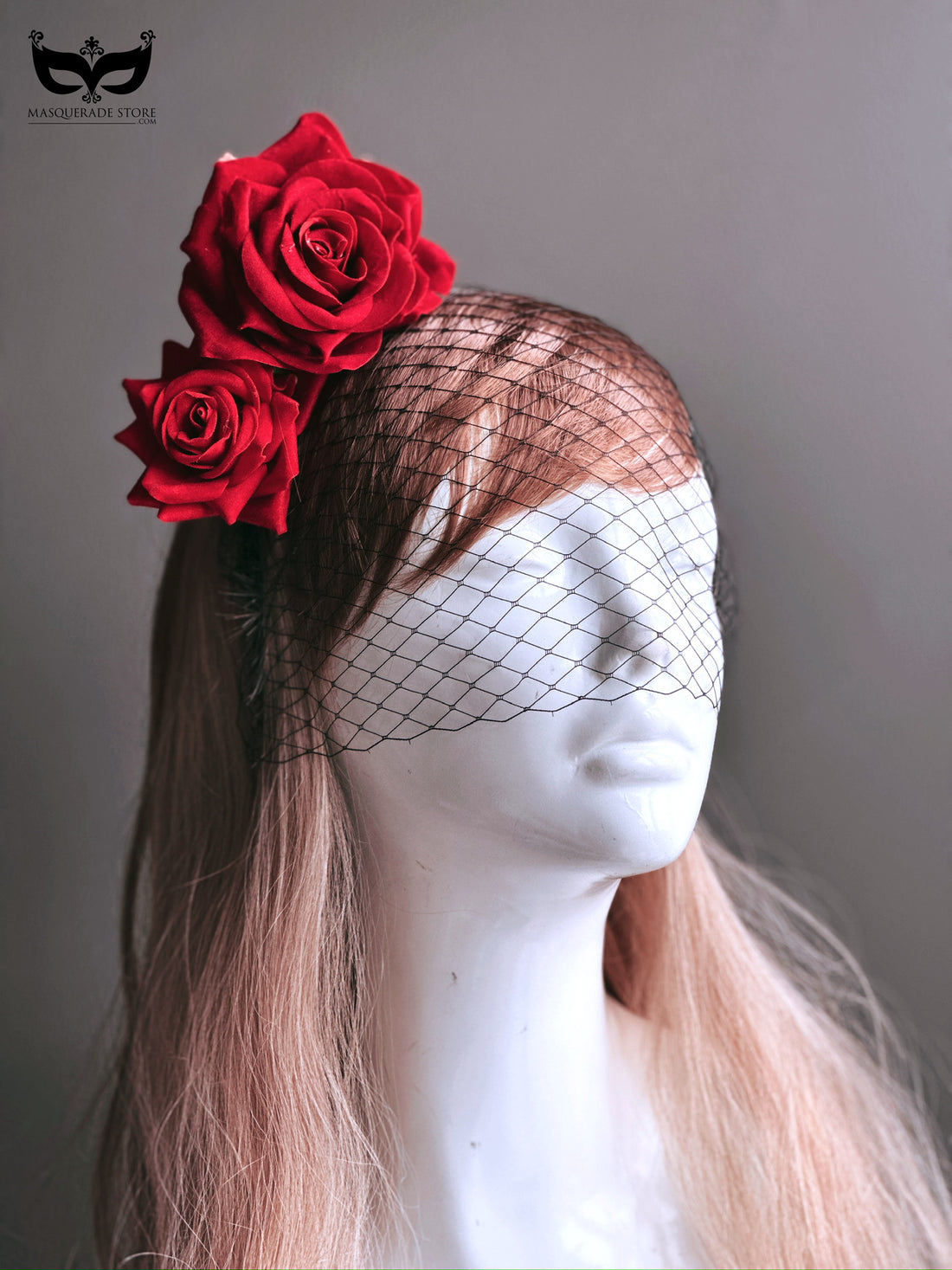 A fascinator adorned with vibrant red roses and a black net veil, ideal for weddings, formal events, and theatrical occasions.