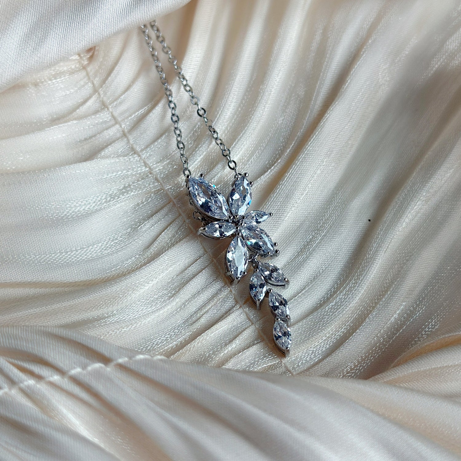  Silver necklace with marquise-cut crystals in a cascading floral-inspired design.
