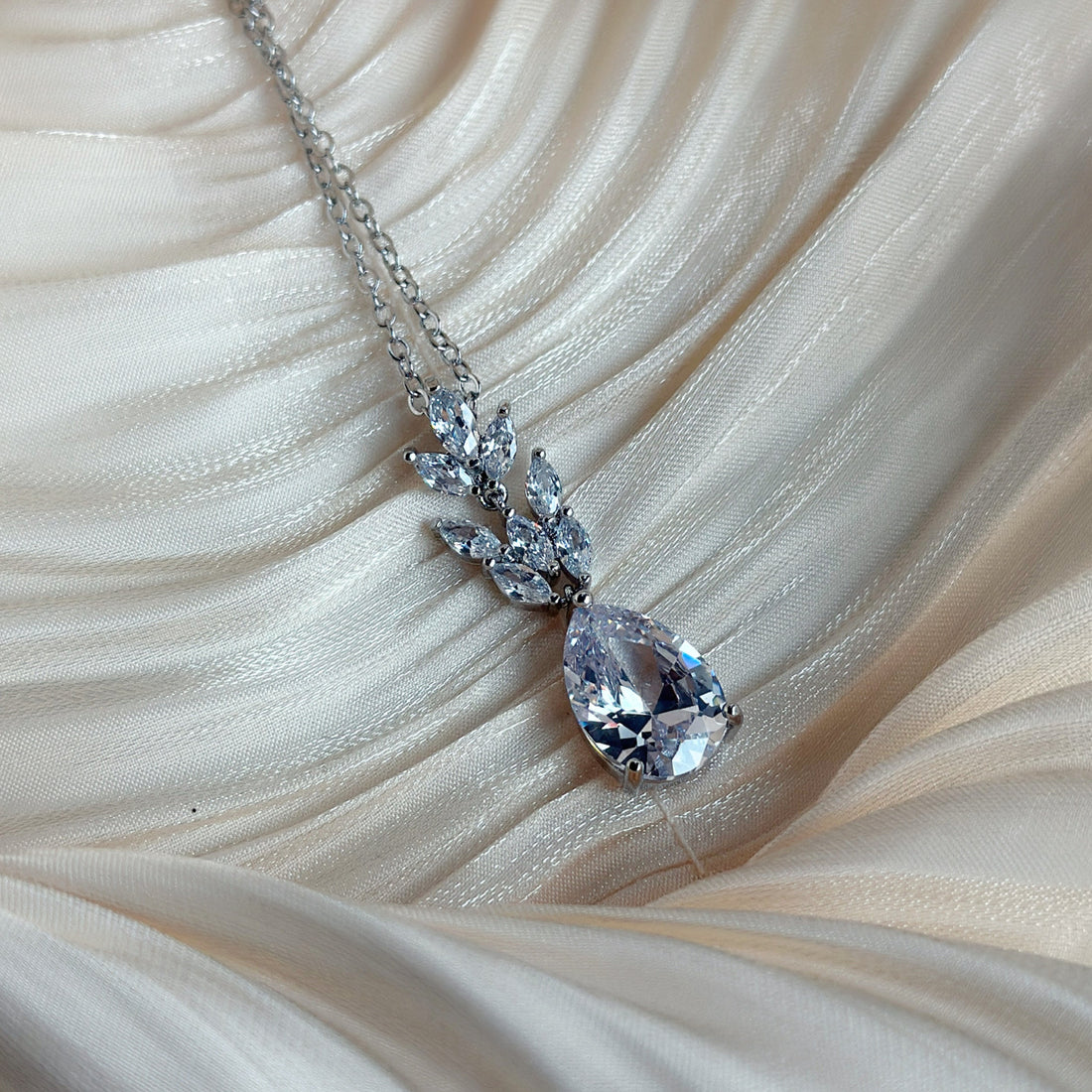 Silver necklace with a teardrop-cut crystal and marquise-cut stones in a floral design.