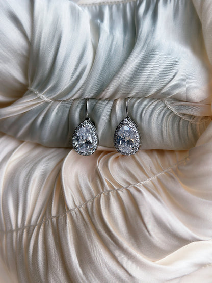 ilver earrings with teardrop-cut crystals surrounded by a halo of sparkling stones.